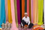 hyderabad Muslim boy in front of a street side fabric shop, Hyderabad.