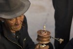 Pilgrim with a prayer wheel near the Jokhang temple, Lhasa.