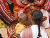 Theyyam artist blesses mother and child, in Kannur District.