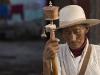 Pilgrim with a prayer wheel near the Jokhang temple, Lhasa.