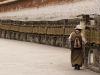 Pilgrim turning prayer wheels while circumambulating the Potala Palace, Lhasa.